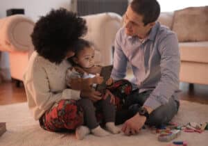 Parents and a baby, sitting on the floor