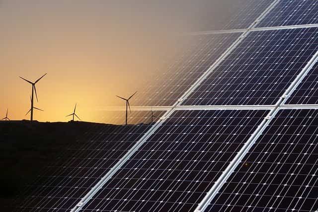 Wind turbines on the left and solar panels on the right, as one of the best home renewable energy options
