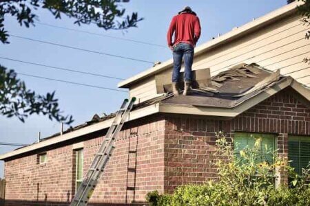 A man in a red jacket standing on the roof
